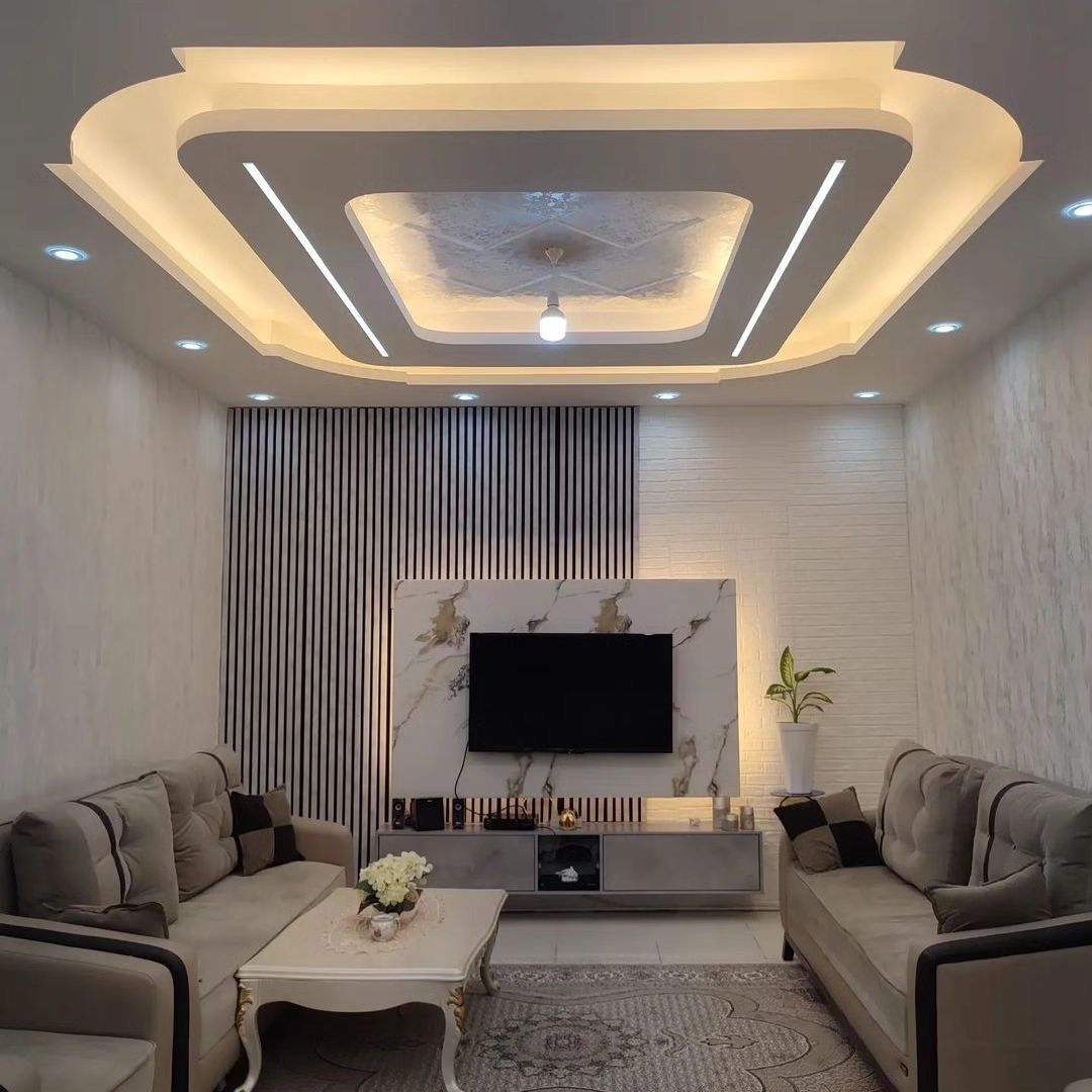 Living room false ceiling with cove lighting and TV wall